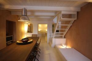 a kitchen and dining room with a table and a spiral staircase at Lydia Cavehouse in Oia