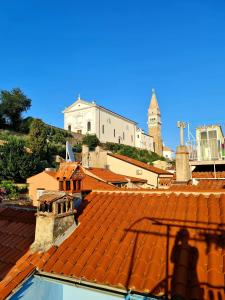 une vue des toits d'une ville avec une église dans l'établissement Seabed Apartma 1, à Piran