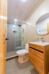 y baño con aseo, lavabo y ducha. en Hotel Mirador de Boquia Salento, en Salento