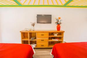 a room with a television on a table with two beds at Hotel Mirador de Boquia Salento in Salento