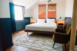 um quarto de hotel com uma cama e uma cadeira em Selina Secret Garden Lisbon em Lisboa