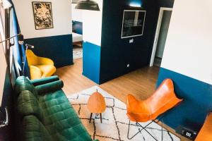 uma sala de estar com um sofá e cadeiras laranja em Selina Secret Garden Lisbon em Lisboa