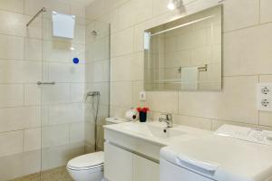 a bathroom with a sink and a toilet and a mirror at Albamar 1a in Puerto de Mogán