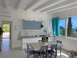 a kitchen and dining room with a table and chairs at Attico vista mare in villa antica in Torre Pali 