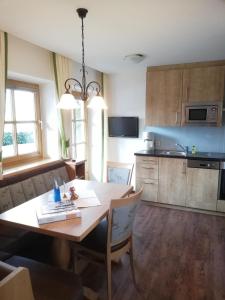 eine Küche mit einem Holztisch und einem Esszimmer in der Unterkunft Landhaus Gruber Winter in Alpendorf