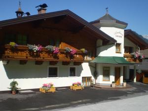 ein großes Gebäude mit Blumenkästen auf dem Balkon in der Unterkunft Landhaus Gruber Winter in Alpendorf