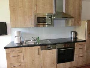 eine Küche mit einer Spüle und einer Mikrowelle in der Unterkunft Landhaus Gruber Winter in Alpendorf