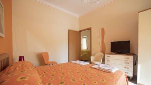 1 dormitorio con 1 cama y vestidor con TV en Residence Mare Blu, en Capo dʼOrlando