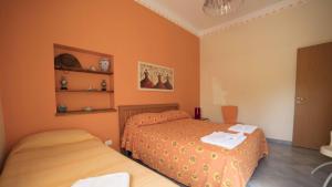 2 Betten in einem Schlafzimmer mit orangefarbenen Wänden in der Unterkunft Residence Mare Blu in Capo dʼOrlando