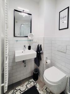 a white bathroom with a sink and a toilet at Das Stader Wohnzimmer in Stade