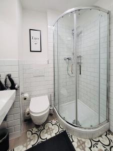 a bathroom with a shower and a toilet and a sink at Das Stader Wohnzimmer in Stade