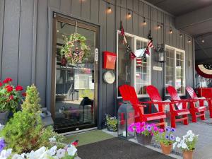 白鱼镇Chalet Inn的餐厅前面摆放着红色椅子和鲜花