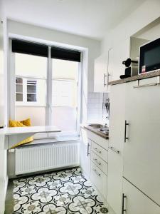 a kitchen with white cabinets and a window at Das Stader Wohnzimmer in Stade