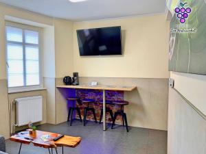 um quarto com um bar com bancos e uma televisão na parede em Fewo Zum Malerwinkel - Rüdesheim em Rüdesheim am Rhein