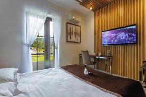 a bedroom with a bed and a television on a wall at Chalet TwoSeasons Bukovel in Bukovel