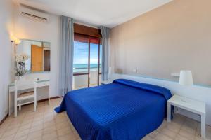 una camera con letto blu e vista sull'oceano di Hotel Sanremo a Lido di Jesolo