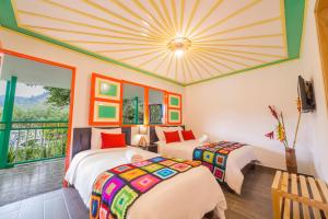 two beds in a room with a ceiling at Hotel Mirador de Boquia Salento in Salento
