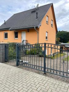 uma casa com uma cerca preta em frente em Oase der Ruhe em Waldsieversdorf
