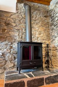 a stone wall with a stove in a room at Casa Rural As Bodegas - Boal in Boal