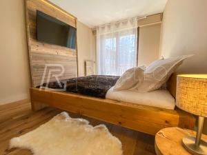 a bedroom with a wooden bed with a window at Appartement Jade Megève 2/4 personnes. in Megève