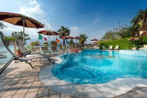 piscina con sedie e ombrellone di Hotel Firenze 3 Stelle Superior a Brenzone sul Garda