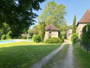 uma estrada de terra que leva a uma casa e a uma piscina em Villa Le Creyssac em Saint-Félix-de-Bourdeilles