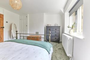 a bedroom with a bed and a dresser and a window at Host & Stay - Waterleap Cottage in Ovingham