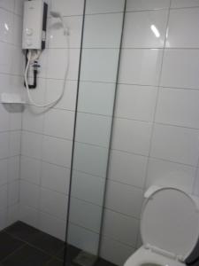 La salle de bains est pourvue de toilettes et d'une cabine de douche. dans l'établissement Ola Hostel, à Malacca