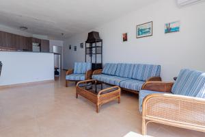 a living room with two blue couches and a screen at Soling 9 in La Manga del Mar Menor