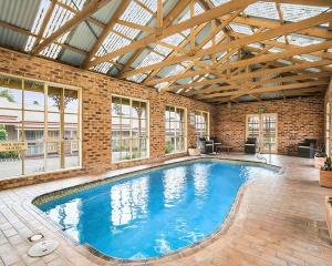 a large swimming pool in a building with a ceiling at Quality Inn Colonial in Bendigo