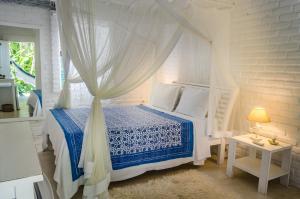 ein Schlafzimmer mit einem Himmelbett in der Unterkunft Pousada Capim Santo in Trancoso
