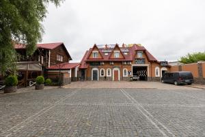 une grande maison avec une voiture garée dans l'allée dans l'établissement Аквамарин, à Biskovichi