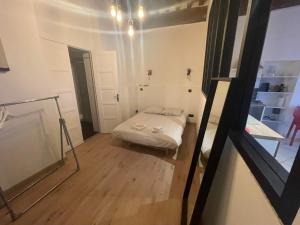 een kleine kamer met een bed en een spiegel bij ARQUEBUSE proche gare in Dijon