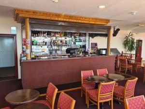 a restaurant with tables and chairs and a bar at Hotel Maria in Sandown