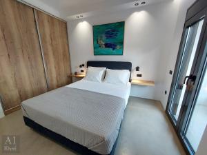 een slaapkamer met een bed en een groot raam bij 10 ApArt Boutique Apartments in Kos-stad