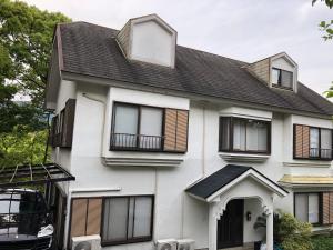 une maison blanche avec des fenêtres et un toit noir dans l'établissement Deer Head, à Itō