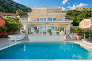リサンにあるBoka Mia - apartments with pool, first lineの家の前にプールがある家