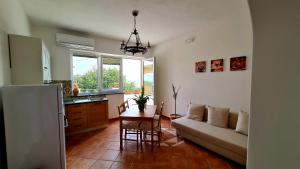 a kitchen and living room with a table and a couch at Scapriccio Relax in Serrara Fontana