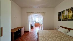 a bedroom with a bed and a desk in it at Scapriccio Relax in Serrara Fontana