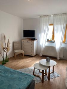 salon z łóżkiem, stołem i telewizorem w obiekcie Ferienwohnung Nele w mieście Waldesch