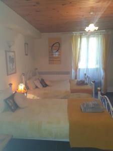1 Schlafzimmer mit 3 Betten und einem Fenster in der Unterkunft Sunset House Chambres de Hotes in Magnac-Laval