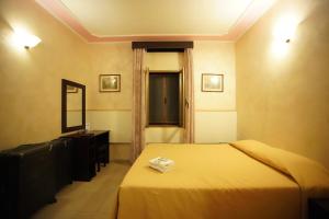 ローマにあるローマ カリナのベッドと鏡が備わるホテルルーム
