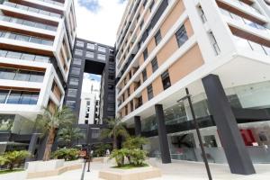 a building in a city with palm trees and buildings at 1440 Lujuso Departamento en Quito - La Recoleta in Quito