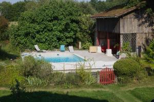 a swimming pool in front of a small building at La Yourte Mongole in Pondaurat