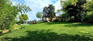 une grande cour avec une maison, des arbres et de l'herbe dans l'établissement Villa Bagnole B&B - Holiday Apartments, à Lonato