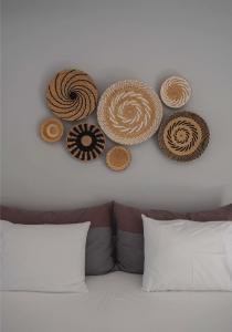 een muur met verschillende hoeden boven een bed bij Archipelagos Studios in Naousa