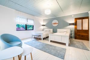 1 dormitorio con 2 camas y silla azul en River House en Bran