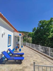 a patio with blue lounge chairs on a house at Casa Serra São Mamede in Alegrete