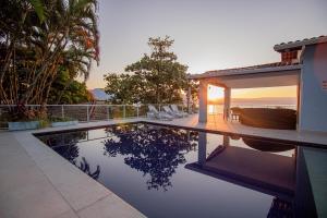 a house with a swimming pool next to a house at Pousada Refúgio das Estrelas - Vista para o Mar in Ilhabela