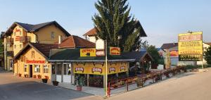 un bâtiment jaune avec un restaurant dans une rue dans l'établissement Guesthouse "INES", à Doboj